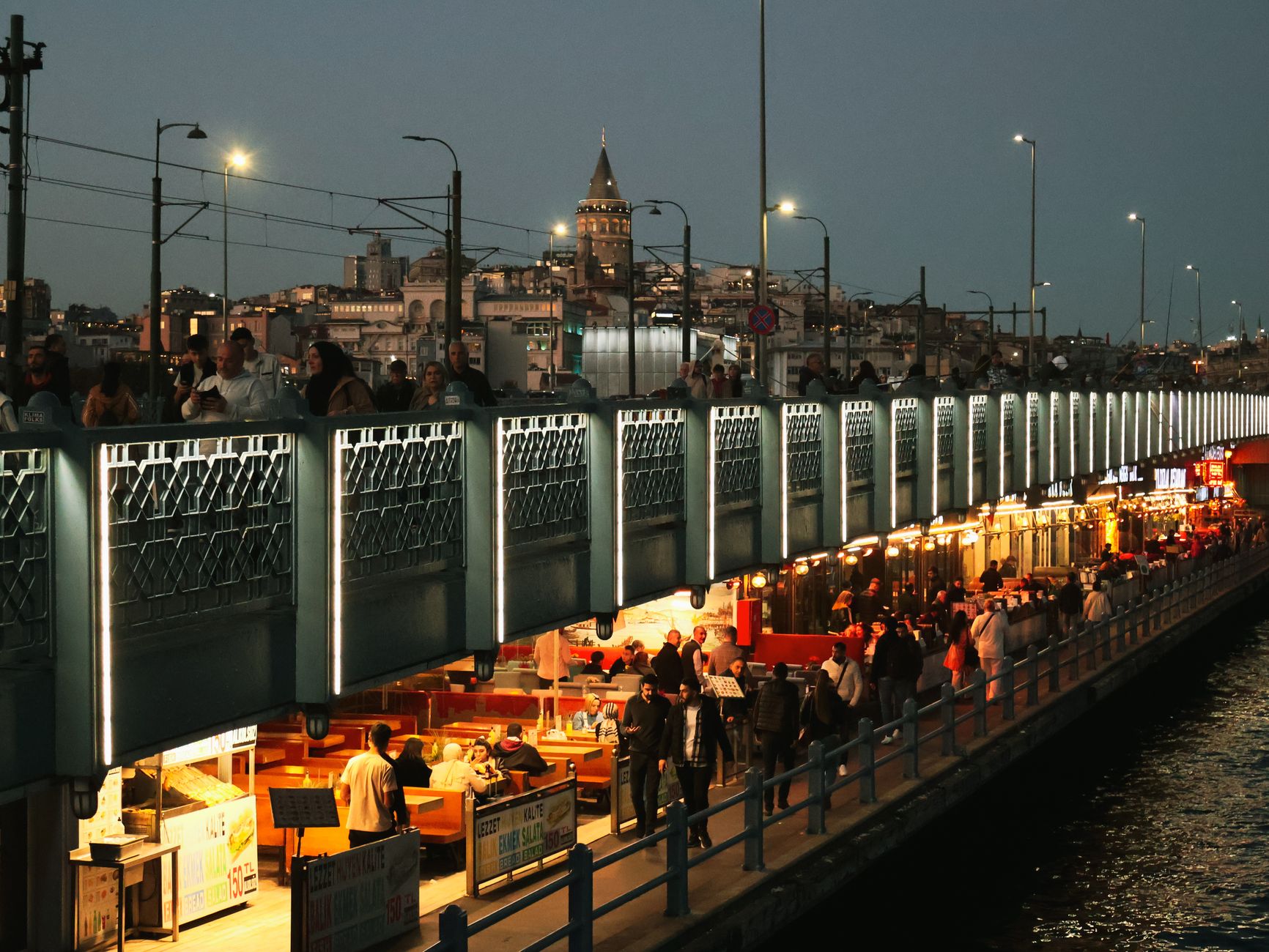 Night view of Galata Bridge bustling with people and distant Galata Tower in Istanbul. — Amplify Your Instagram Presence: The