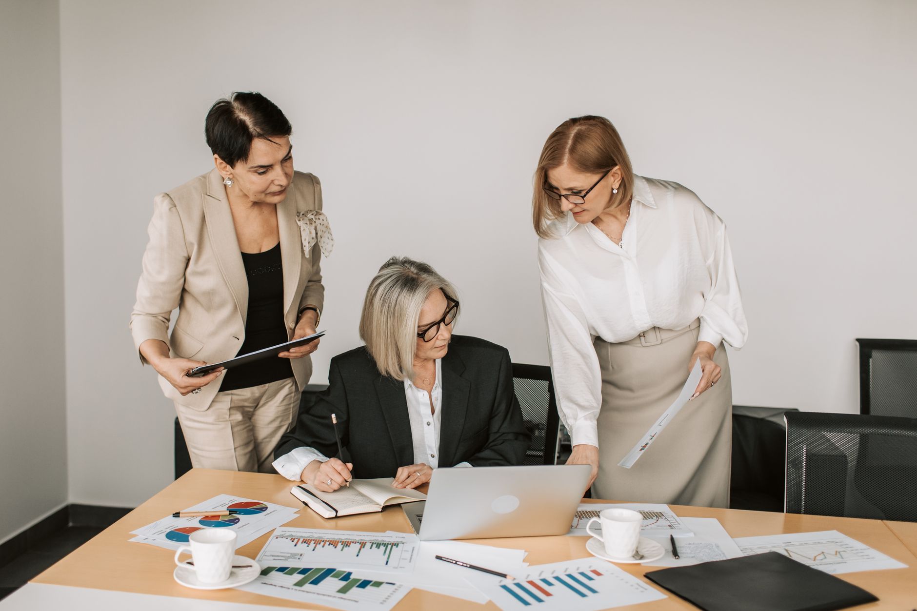 Three businesswomen discussing documents during a meeting in a modern office setting. — Behind the Scenes of NBA Streaming: N
