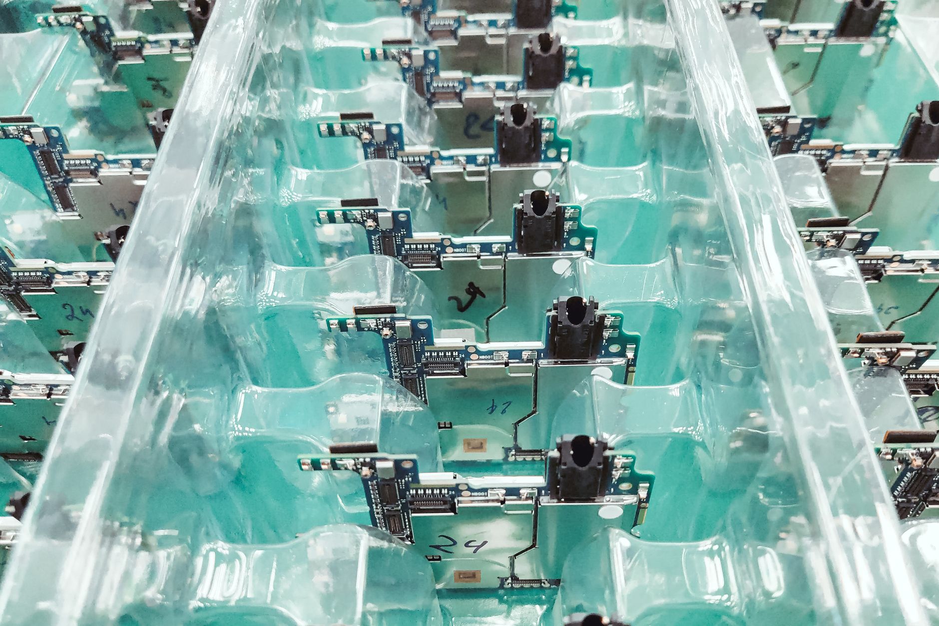 Detailed view of organized electronic circuit boards in a production setting. — Binding Machines Versus Electronic Proposals