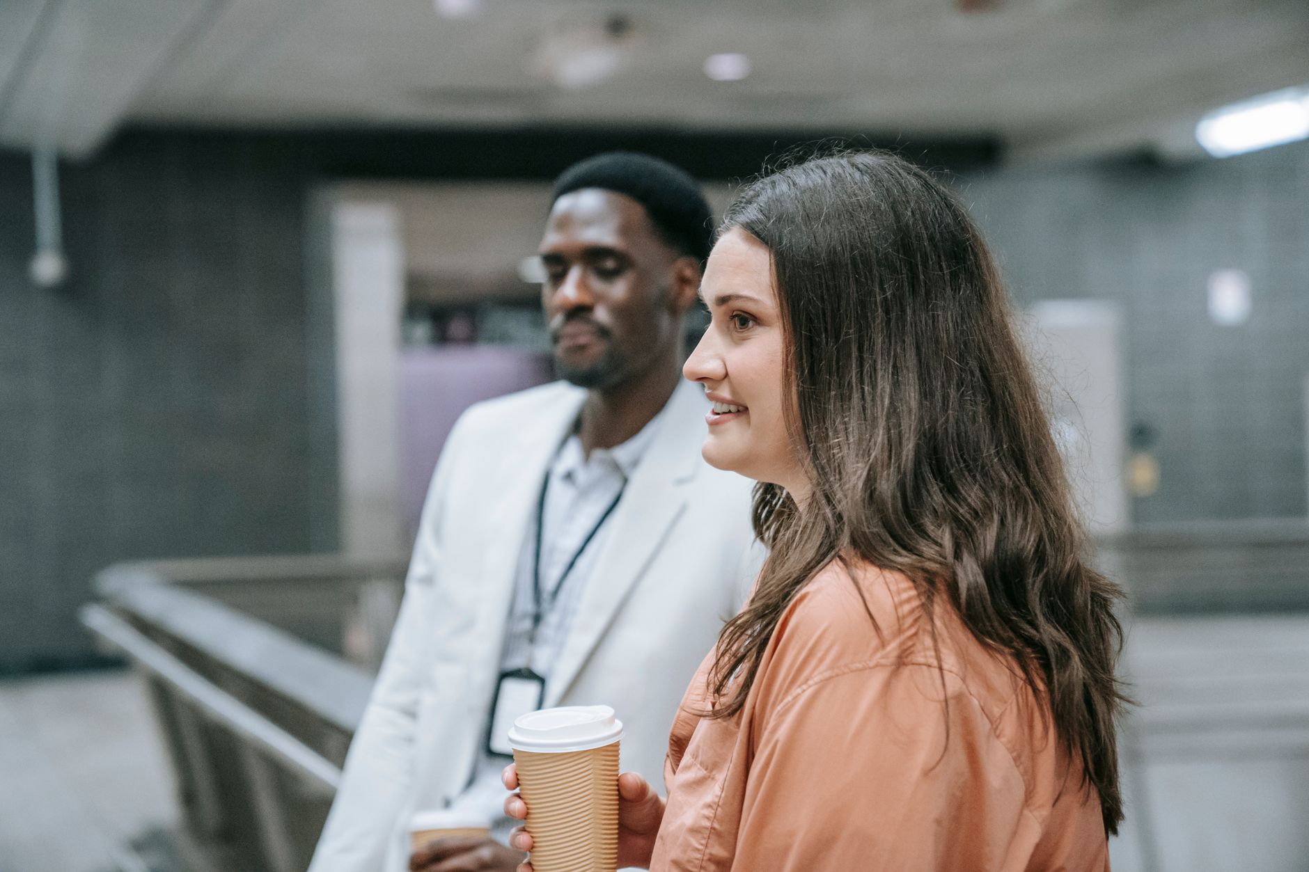 Two young adults chatting over coffee in a subway station, embracing urban lifestyle and networking. — DISH Network Specials