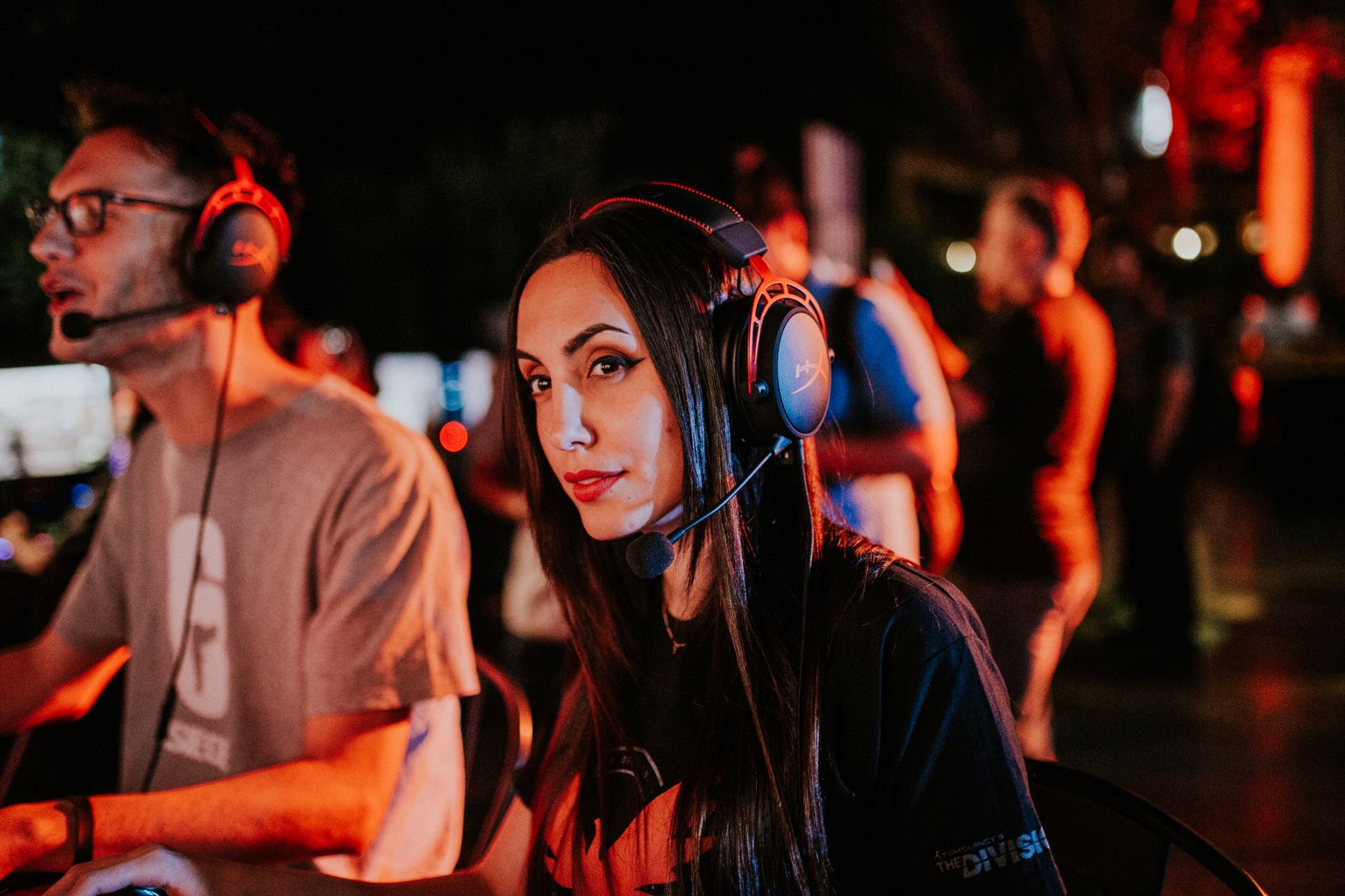 Woman gaming in esports tournament, wearing headset with focused expression, dimmed indoor lighting. — Get Ready to Play Exci