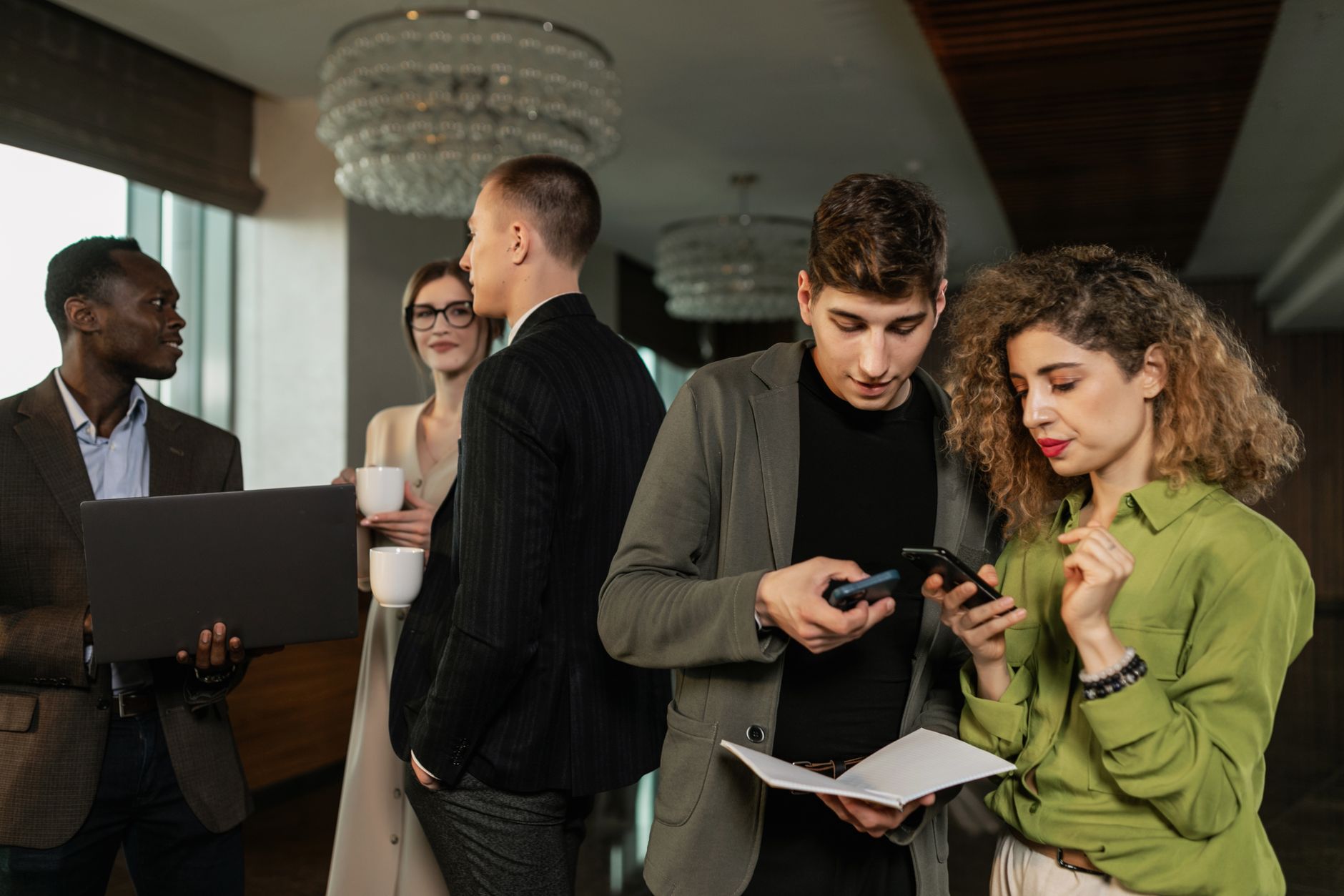 Group of diverse business professionals networking indoors with smartphones and coffee. — Network Security