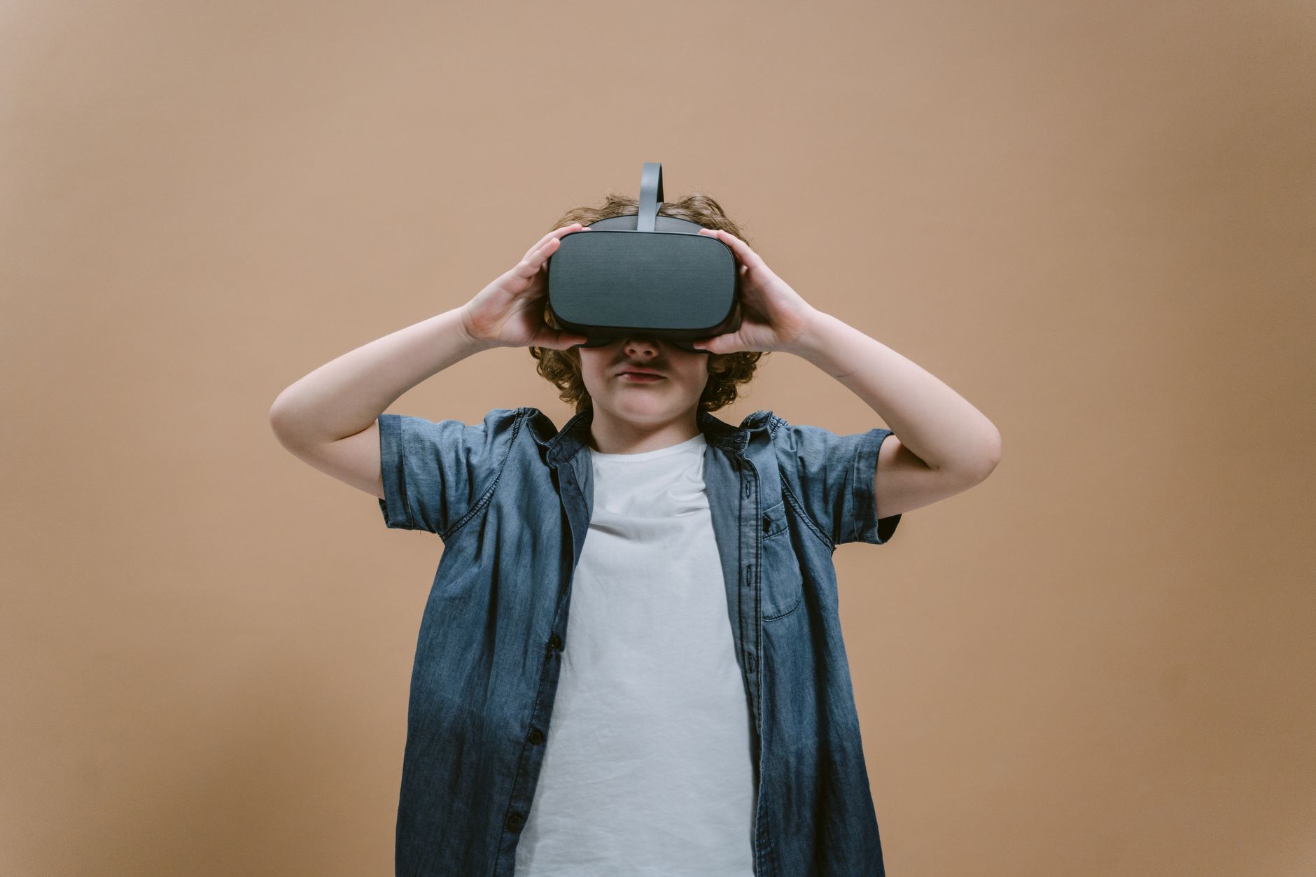 Child in studio using VR headset, engaging with modern technology on a plain background. — How to make the most out o