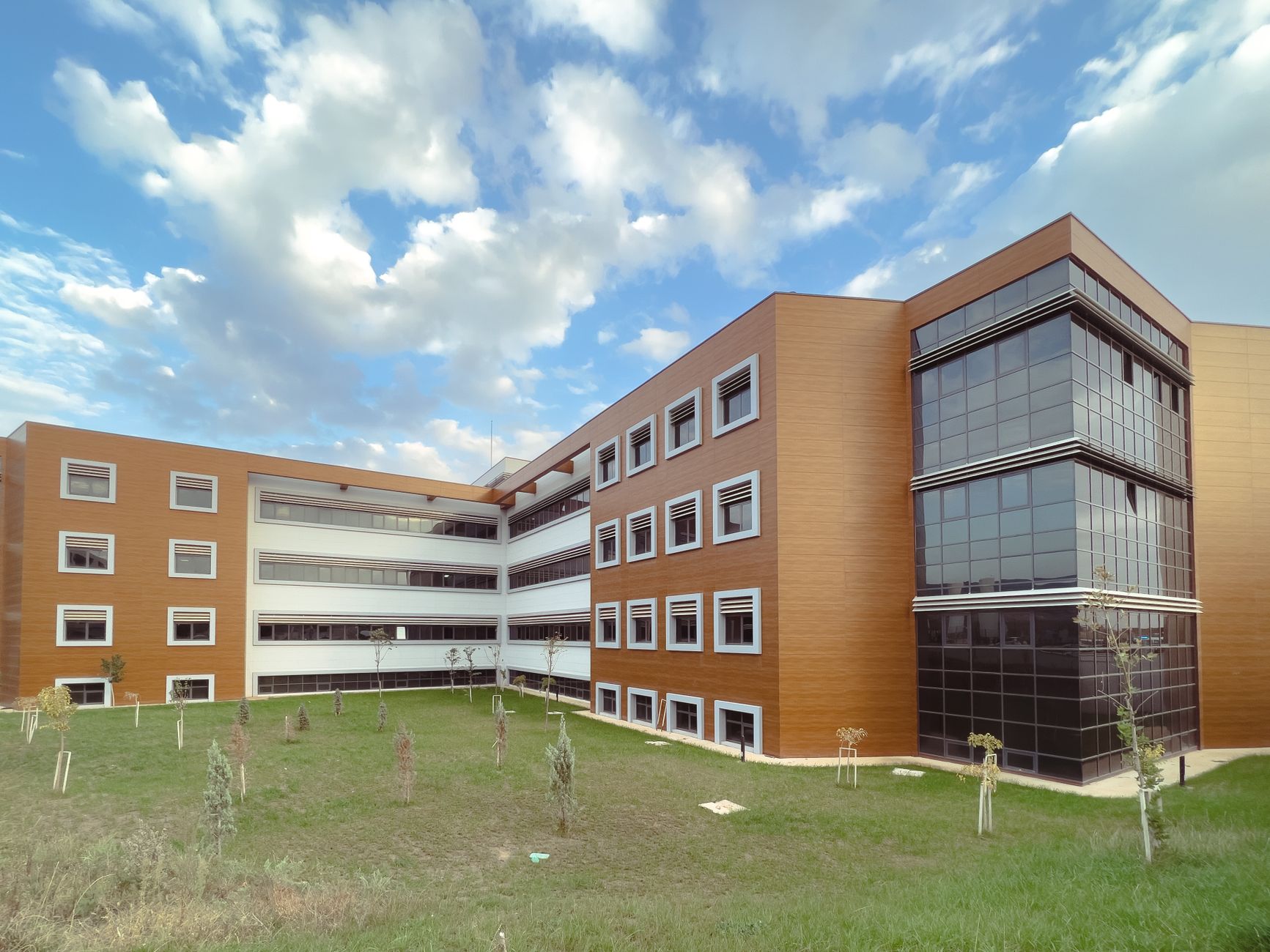 A modern educational building with a grassy lawn and partly cloudy sky. — Is It Safe To Buy From Unknown Providers Fo