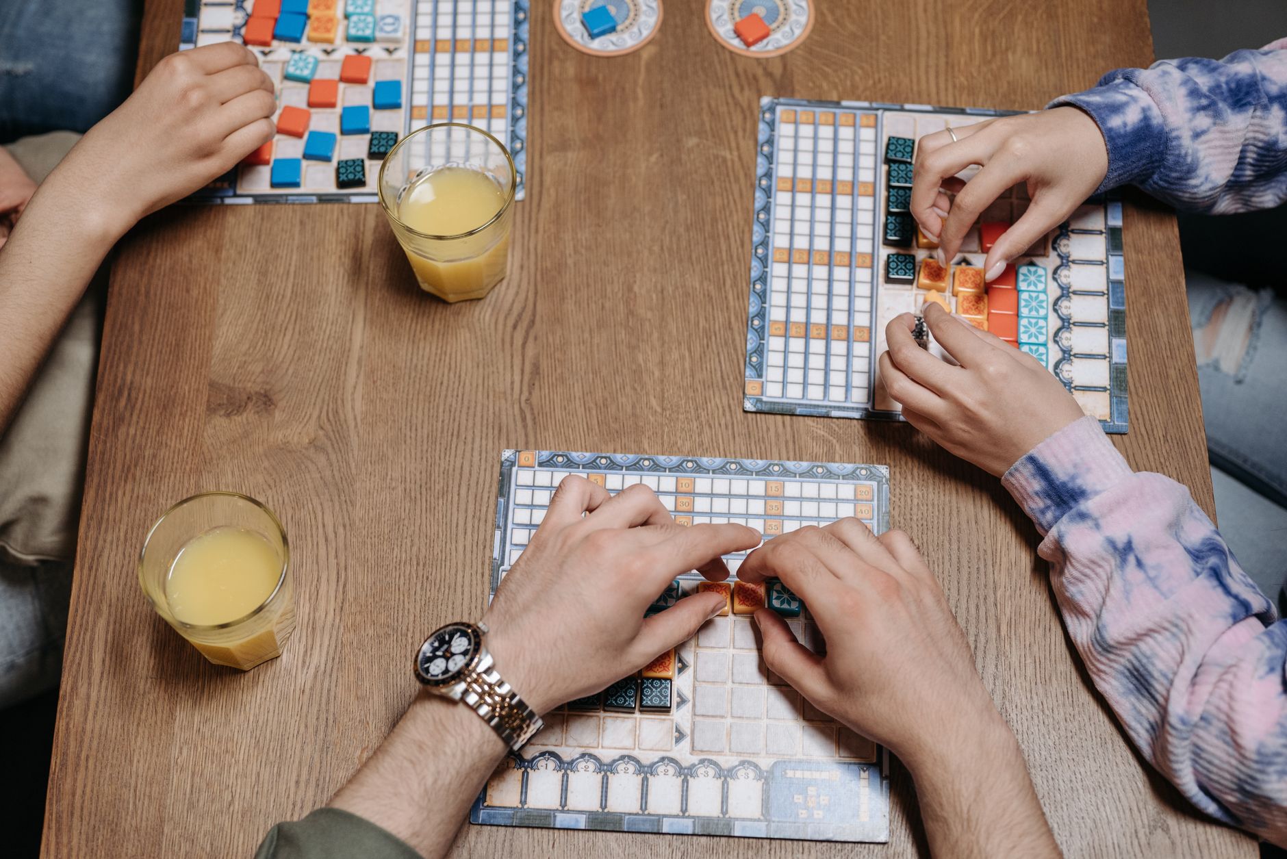 Close-up of hands and board game tiles during a fun gaming session indoors. — What Are The Common Bets In fun88asia.com login
