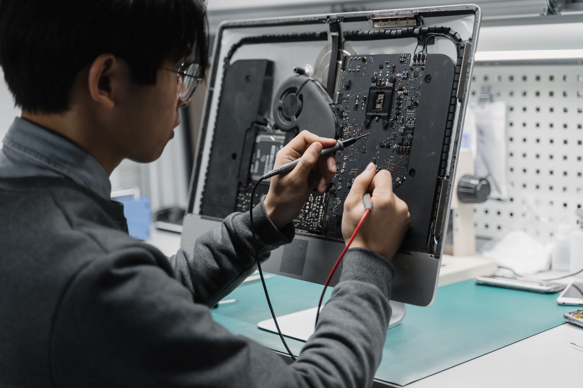 A technician works on a computer motherboard using tools at a workspace, focusing on electronics repair. — What is Expired Do